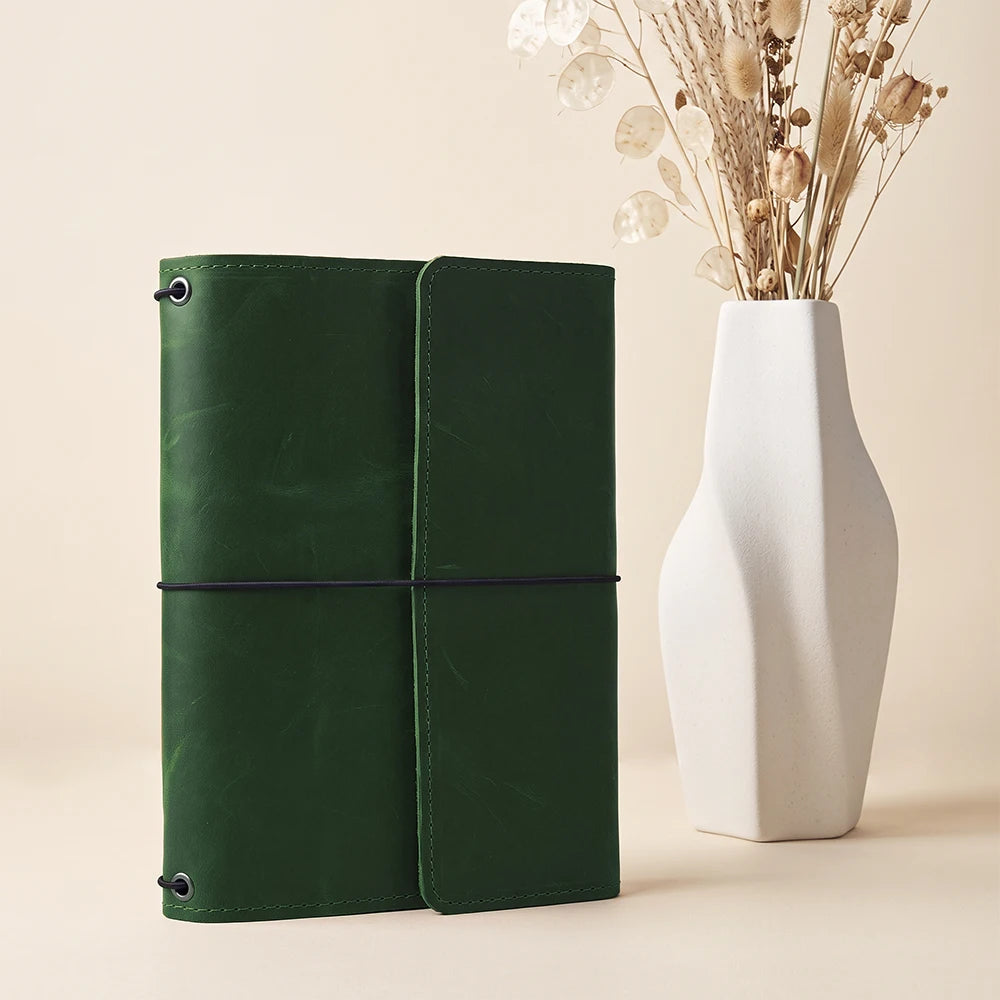 Leather journal cover with refillable notebook system, pen holder, and multiple inside compartments.