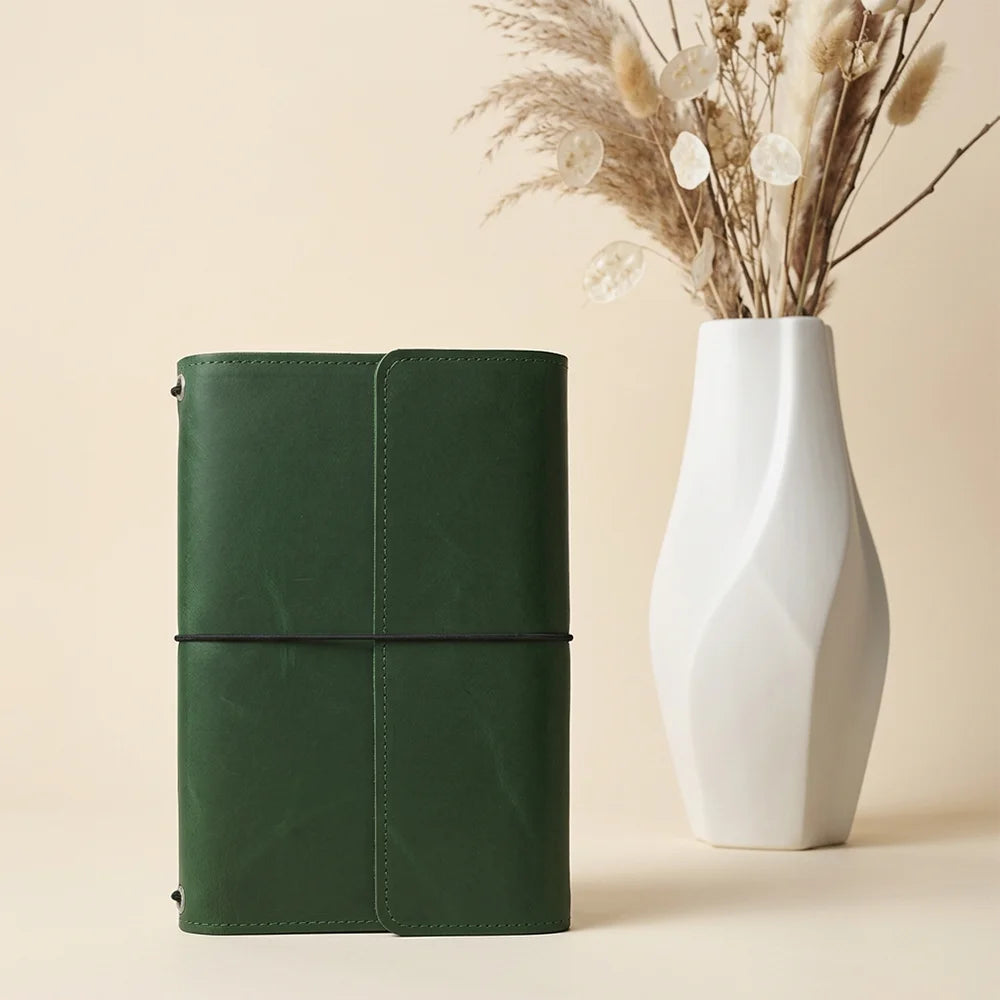 Natural leather planner case featuring interior organizers and a specially designed pen attachment.