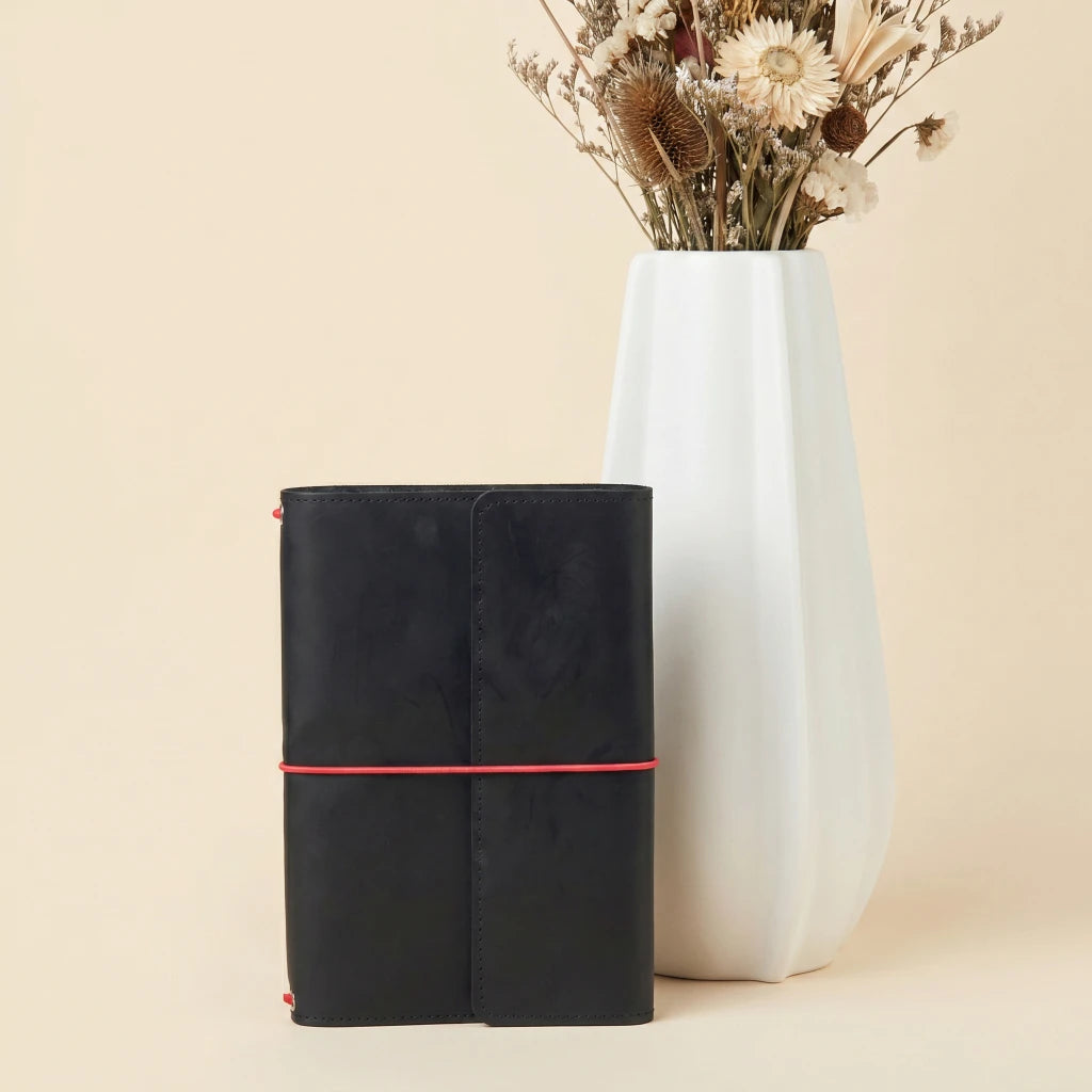 Refillable leather planner cover with elastic bands and organized pocket interior