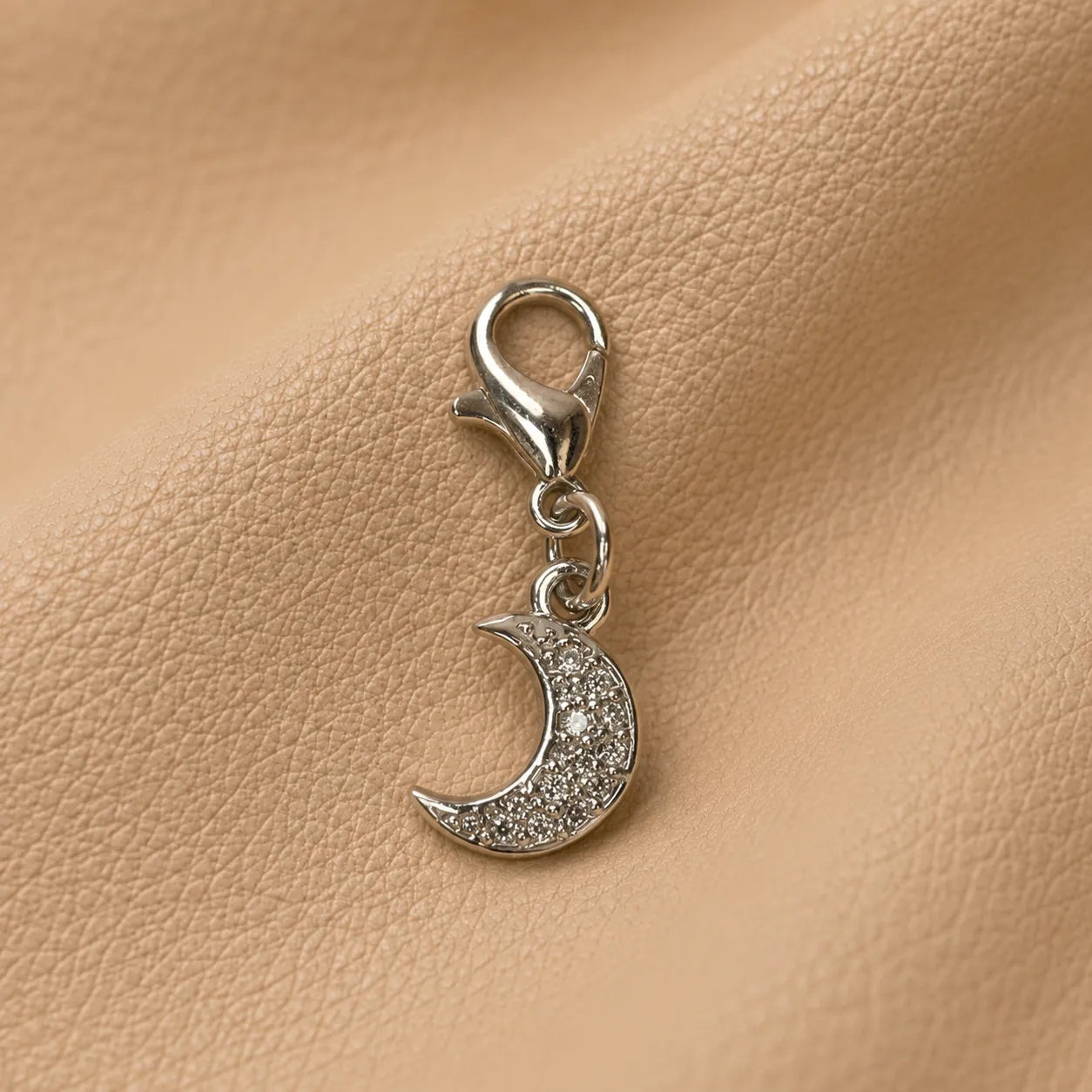 Metal crescent moon charm for refillable journal, decorative accessory secured to notebook elastics.