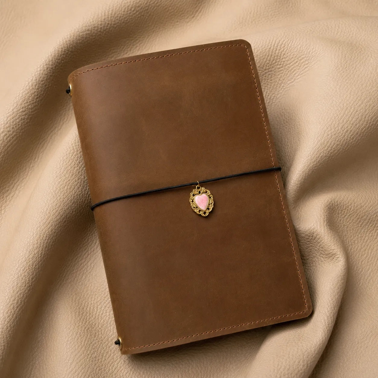 Heart notebook charm attached to elastic band, stylish journal accessory for everyday planning.