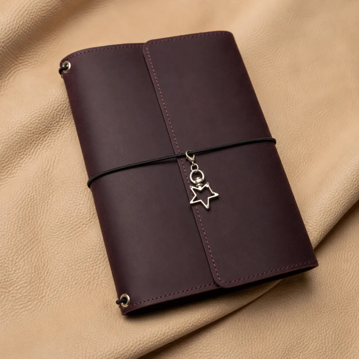 Elegant star-shaped journal charm adding a unique touch to refillable leather notebooks.