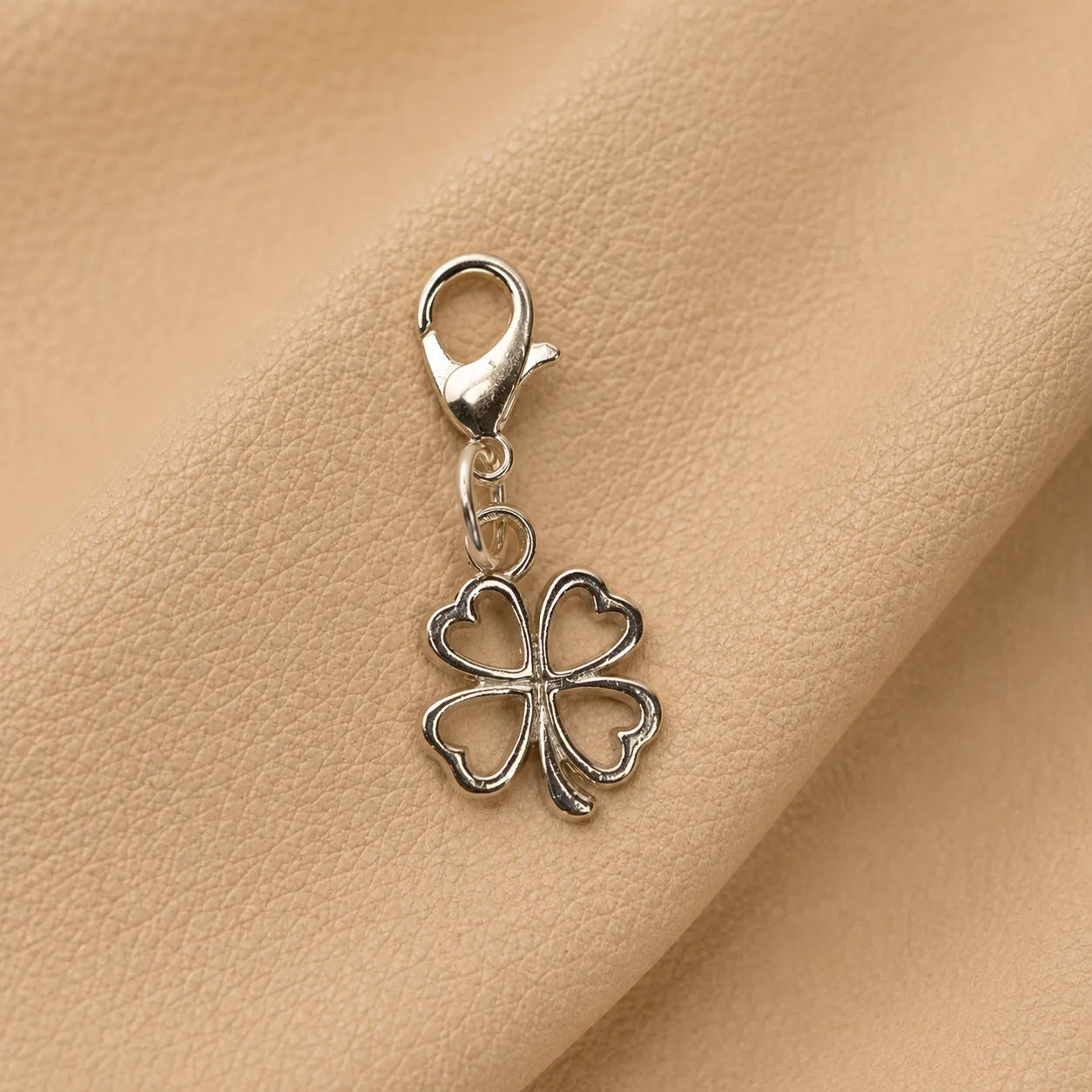 Decorative clover notebook charm with metal clasp secured to elastic journal bands.