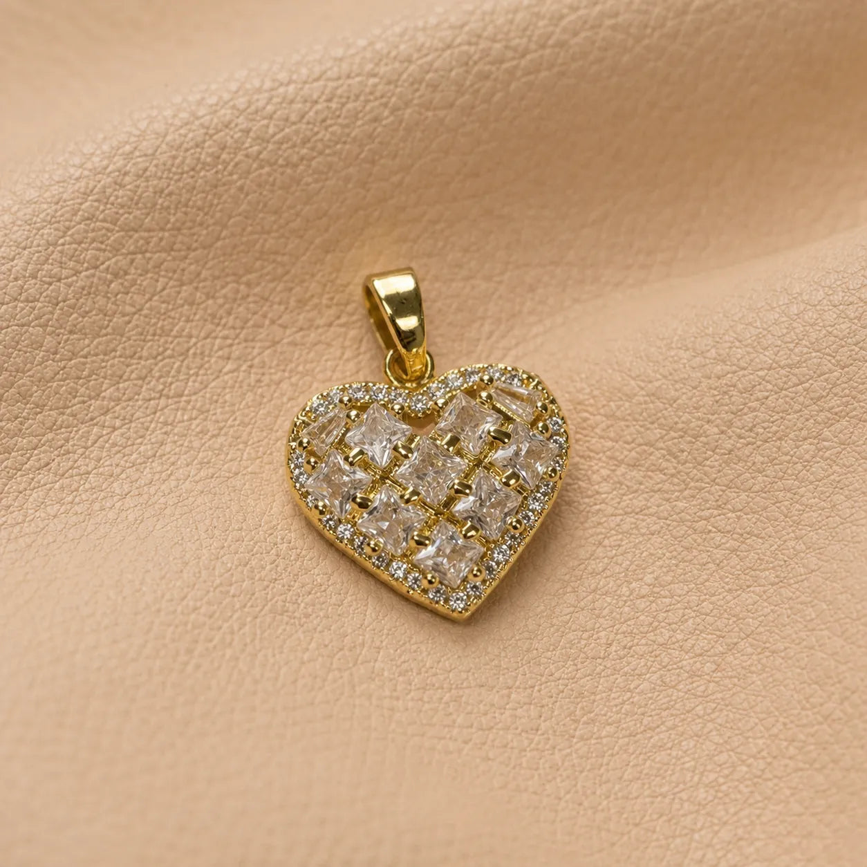 Heart-shaped journal charm attached to a leather notebook, adding a sweet decorative accent.