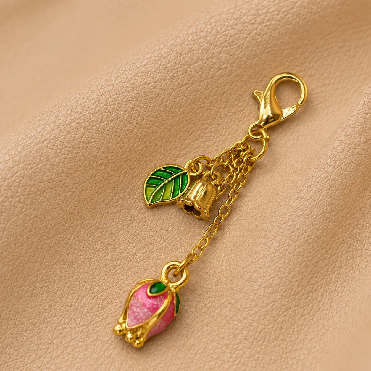 Delicate floral notebook charm hanging from elastic bands, adding a stylish handcrafted accent.