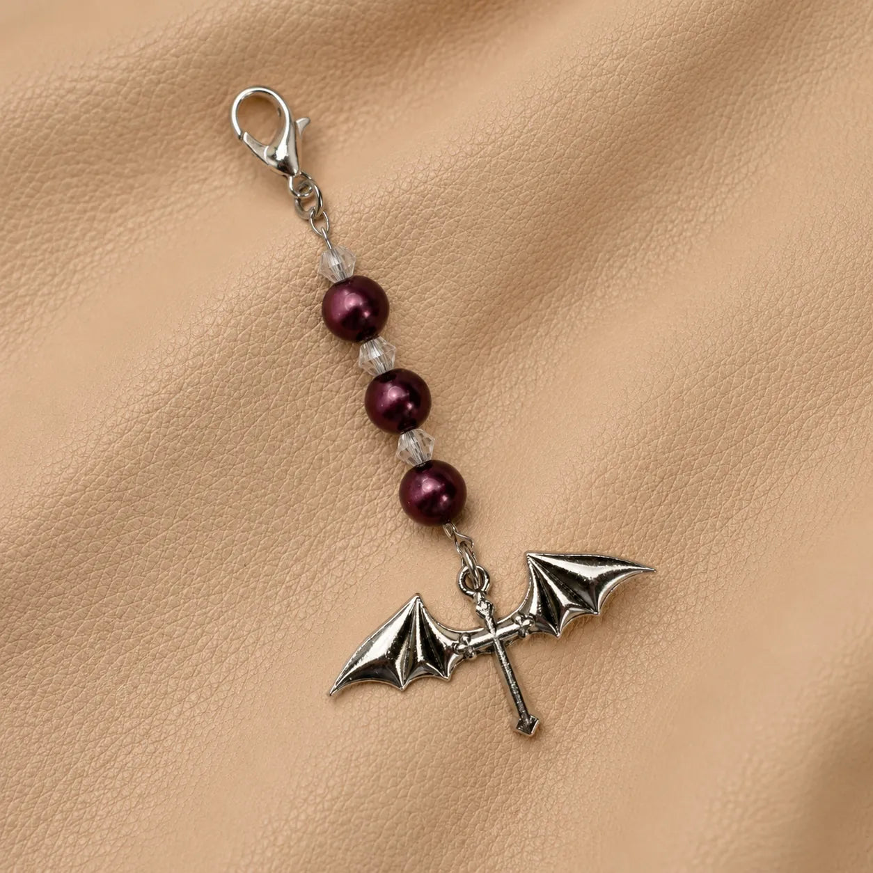 Beaded journal charm attached to a leather notebook elastic band for elegant decoration.