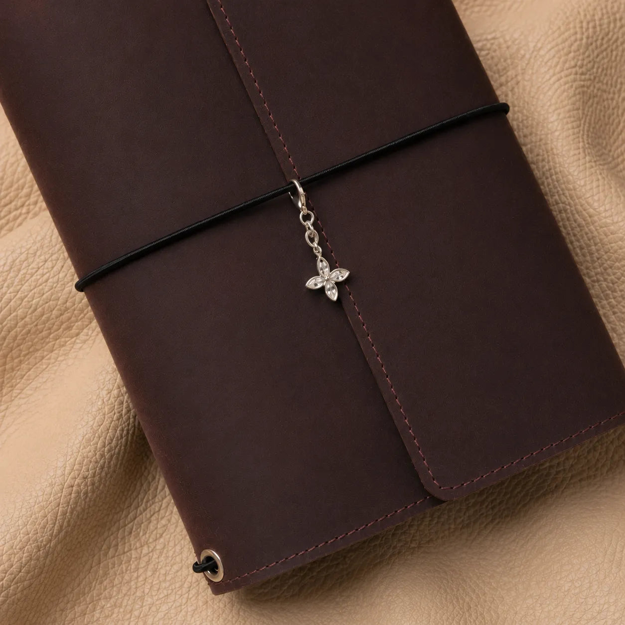 Flower-shaped journal charm attached to elastic bands, elegant beaded accessory for leather notebooks.
