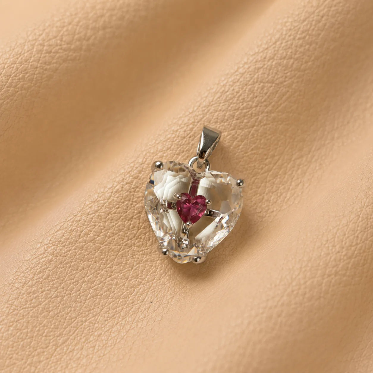 Heart-shaped journal charm attached to a leather notebook, decorative planner accessory with metal clasp.