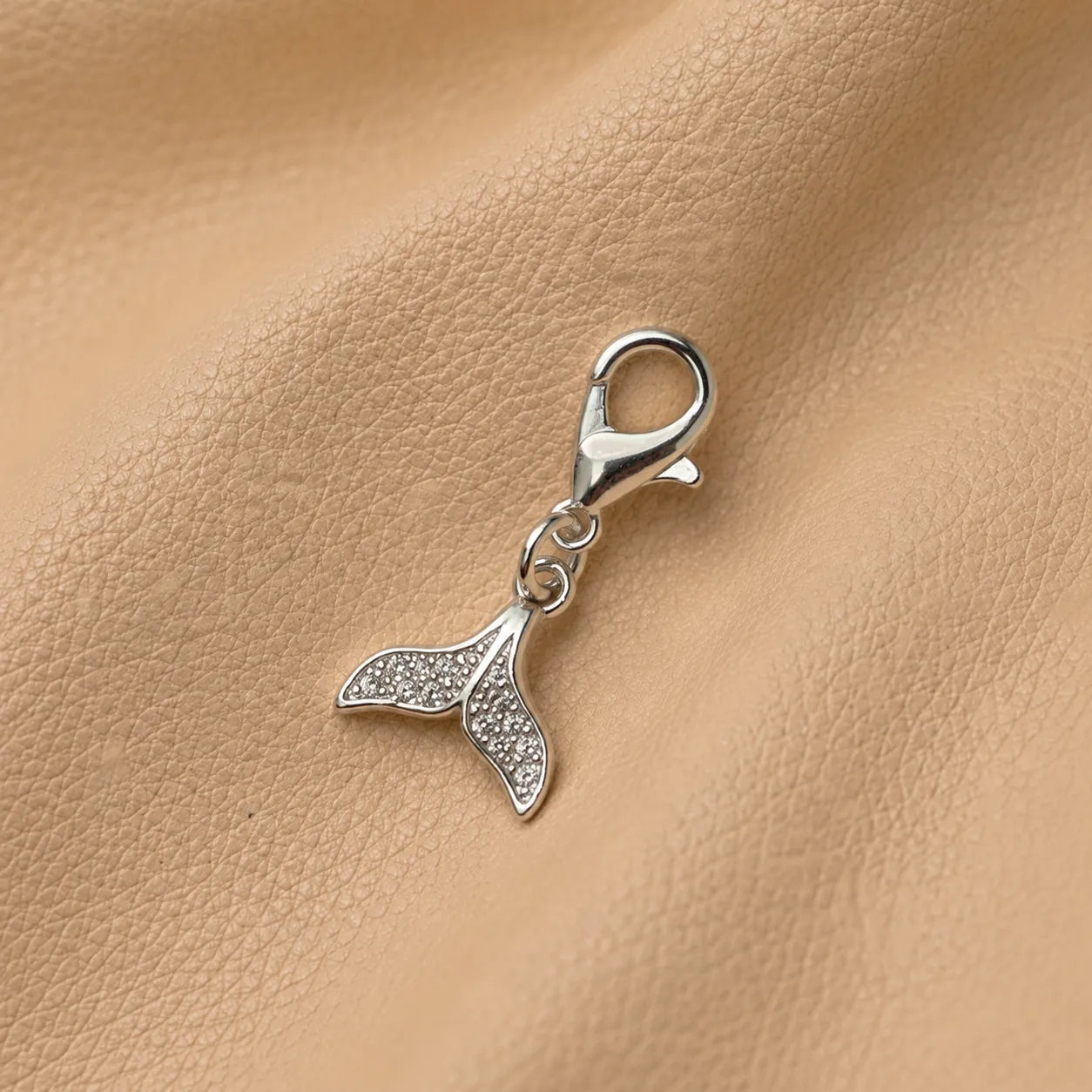Whale tail journal charm with beaded design attached to notebook elastic bands for decoration.