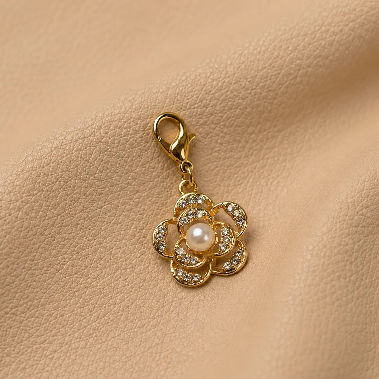 Flower-shaped journal charm bead attached to a leather notebook elastic band.
