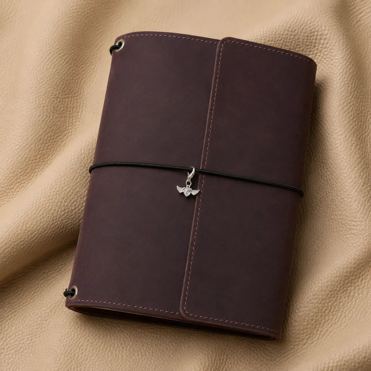 Heart-shaped journal charm attached to notebook elastic band, elegant planner accessory for daily use.