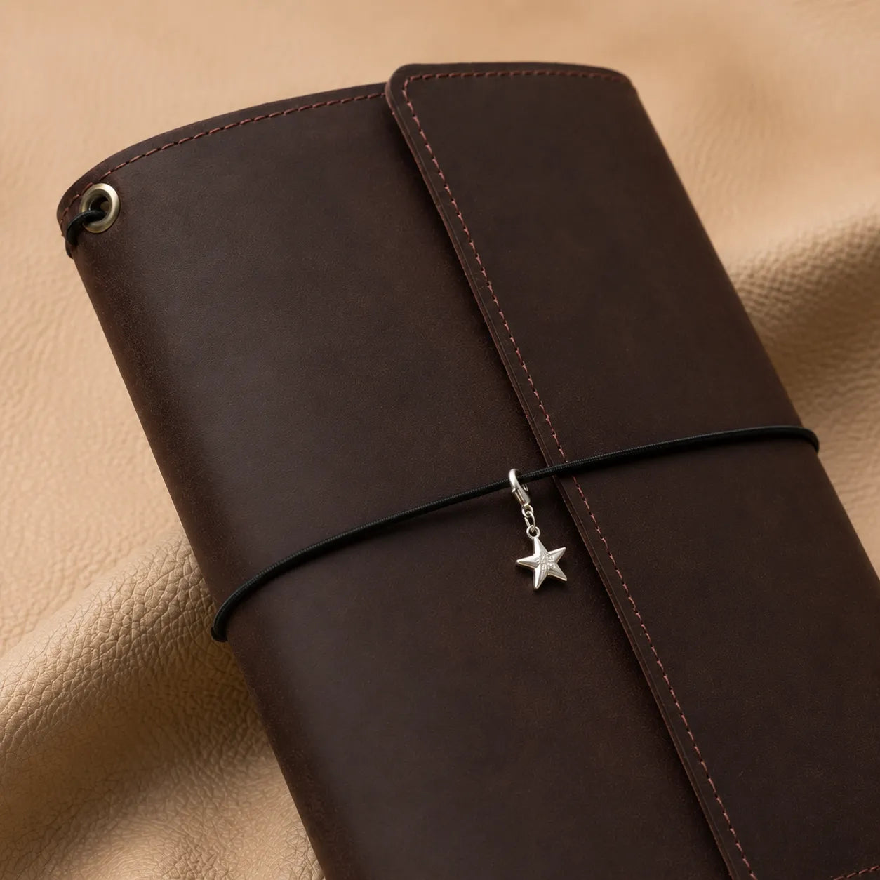 Star journal charm attached to elastic bands for stylish notebook personalization.