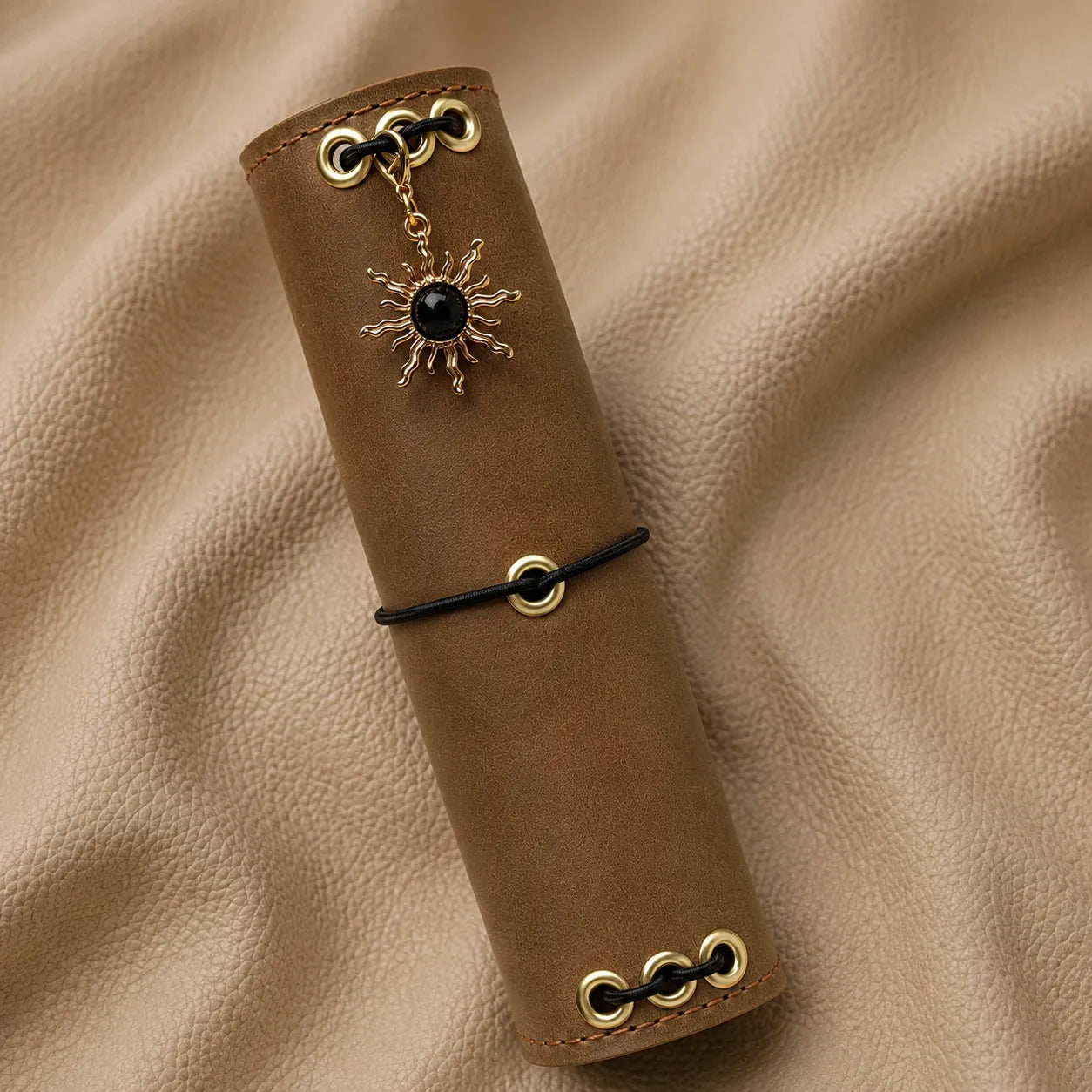 Decorative sun journal charm with a black gemstone, designed to personalize a traveler's notebook.