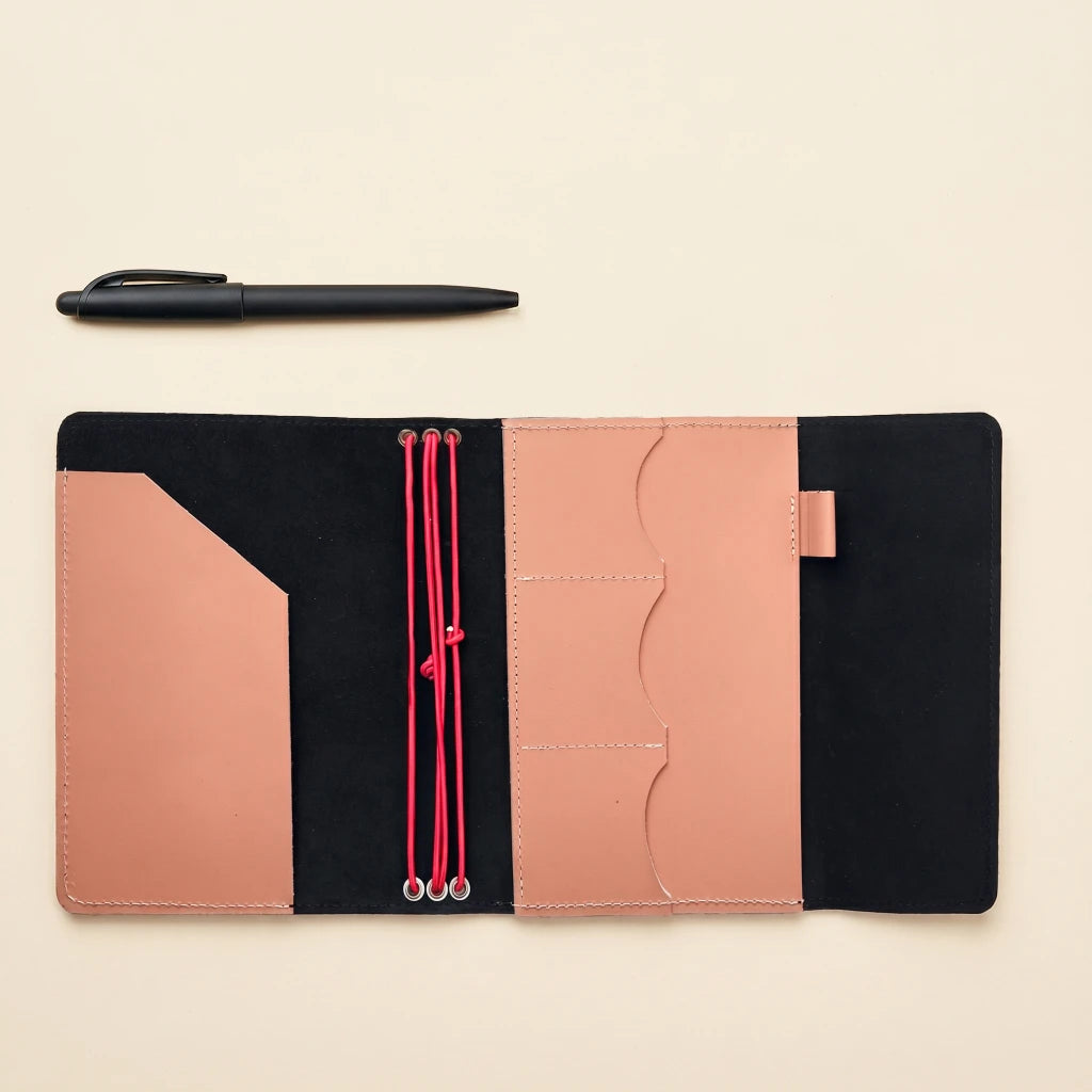 Handcrafted leather notebook cover secured with elastic bands and simple style
