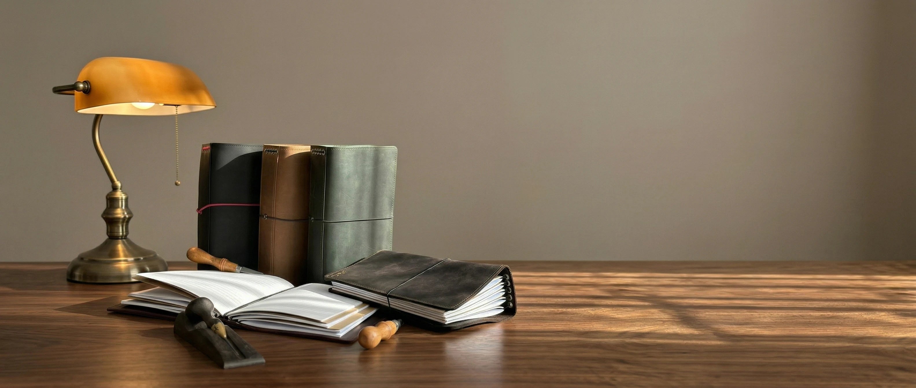 Books and a lamp on a wooden table with a plain background