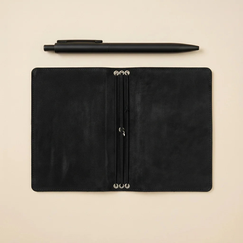 Black leather journal on a beige background