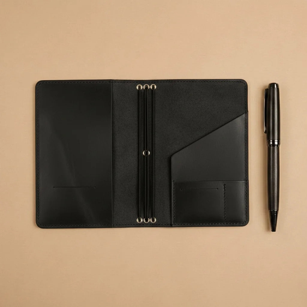 Black leather folio with pen on a beige background
