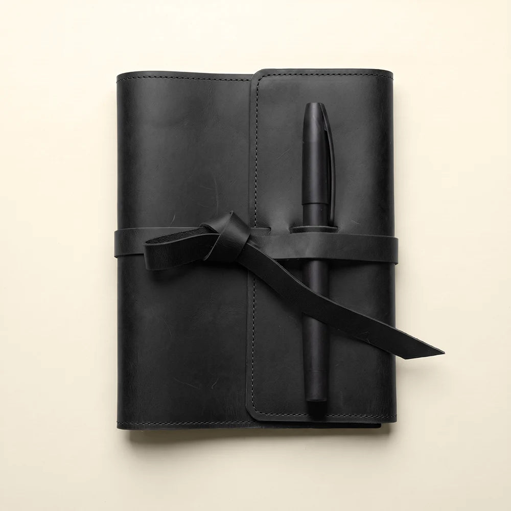 Refillable leather planner cover with organized pockets and secure pen holder.