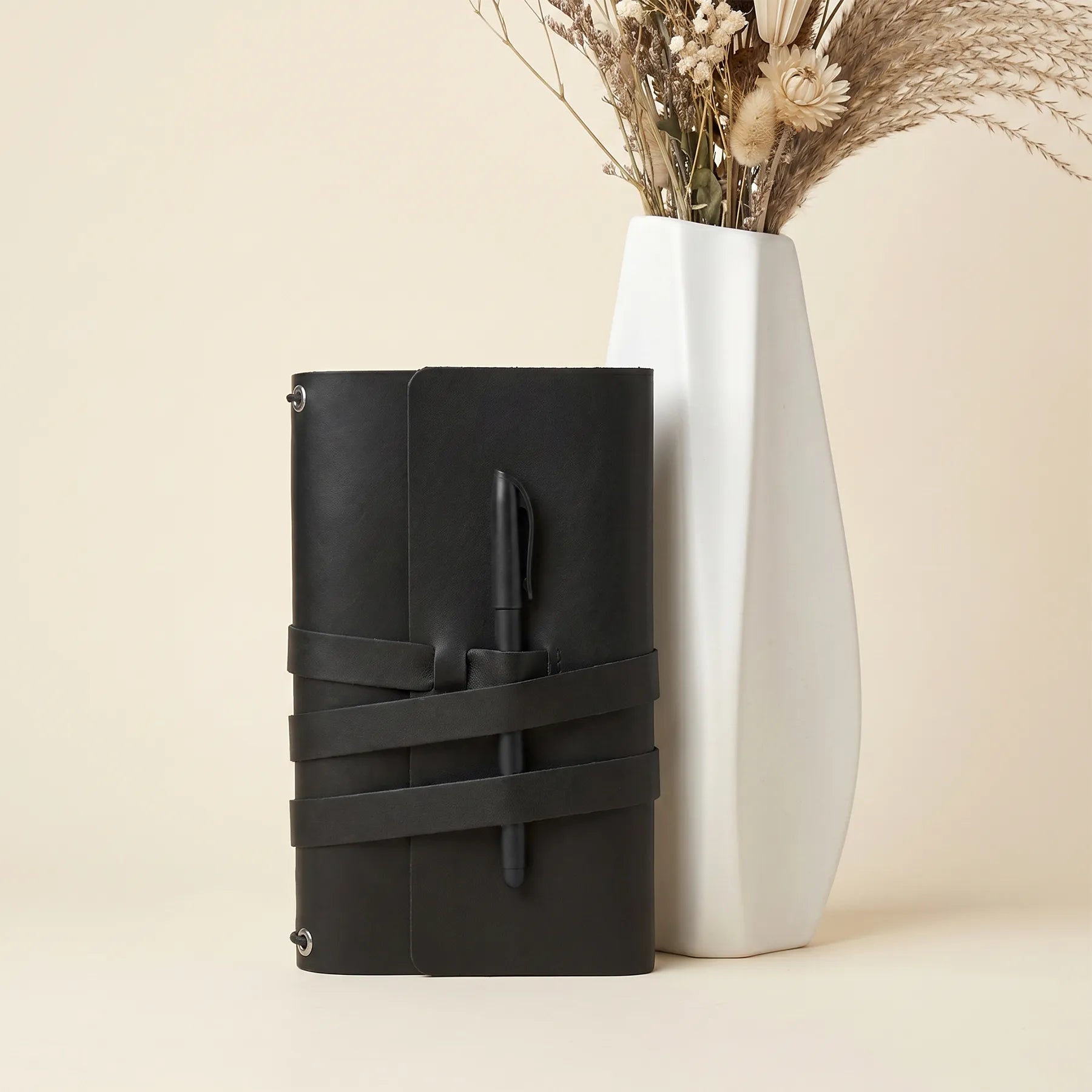 Handmade leather notebook cover combining premium craftsmanship with functional pen holder loops.