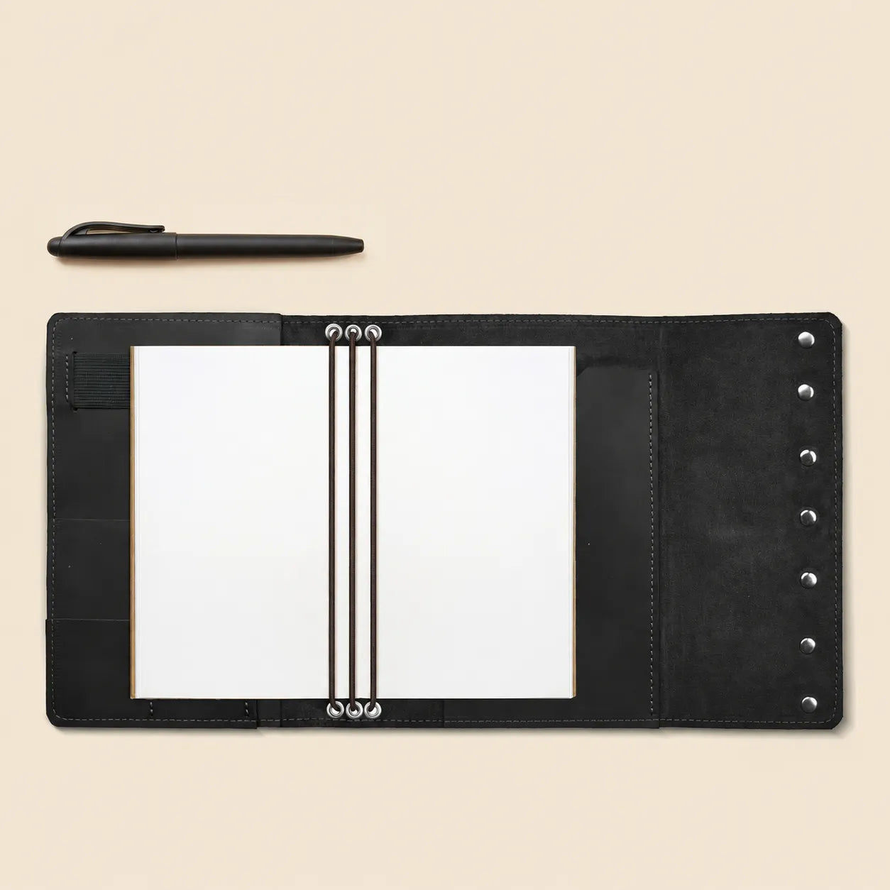 Genuine leather refillable notebook cover with inside pockets and pen holder.