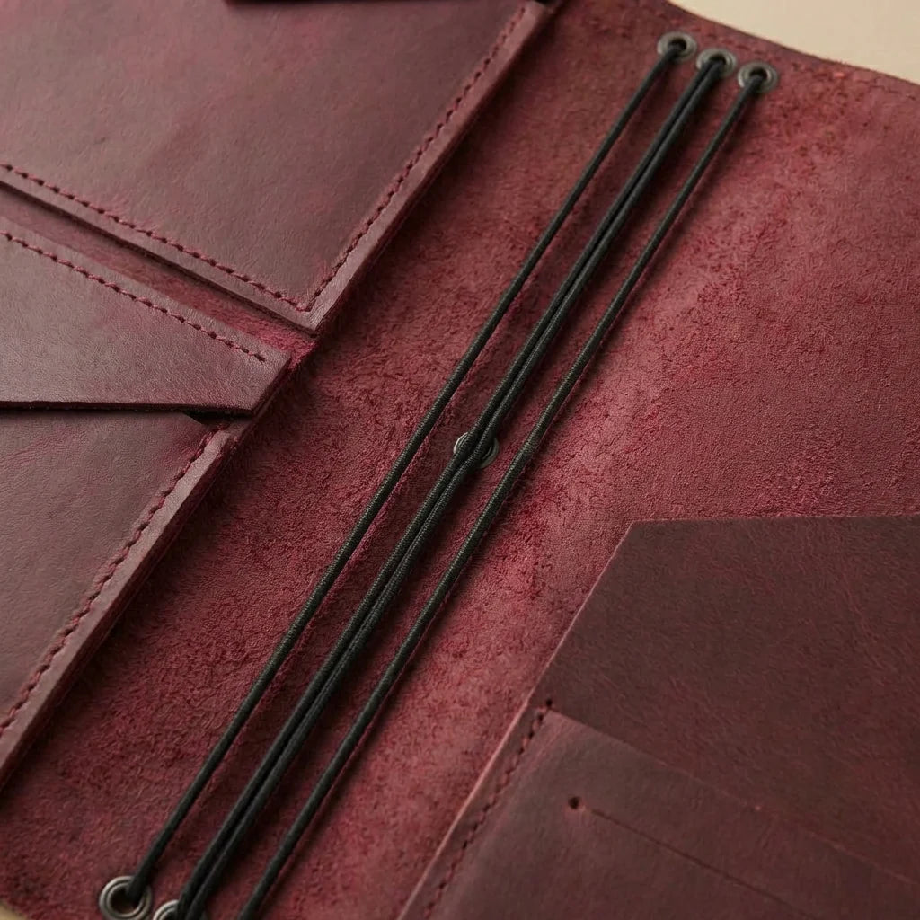 Close-up of a maroon leather journal cover with black stitching
