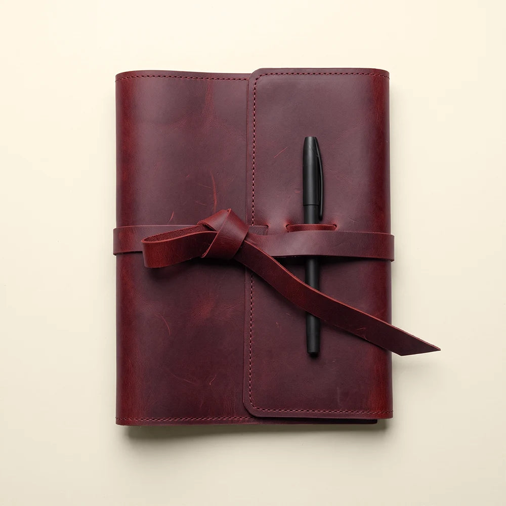 Handmade journal cover in leather with practical pockets and pen carrying loop.