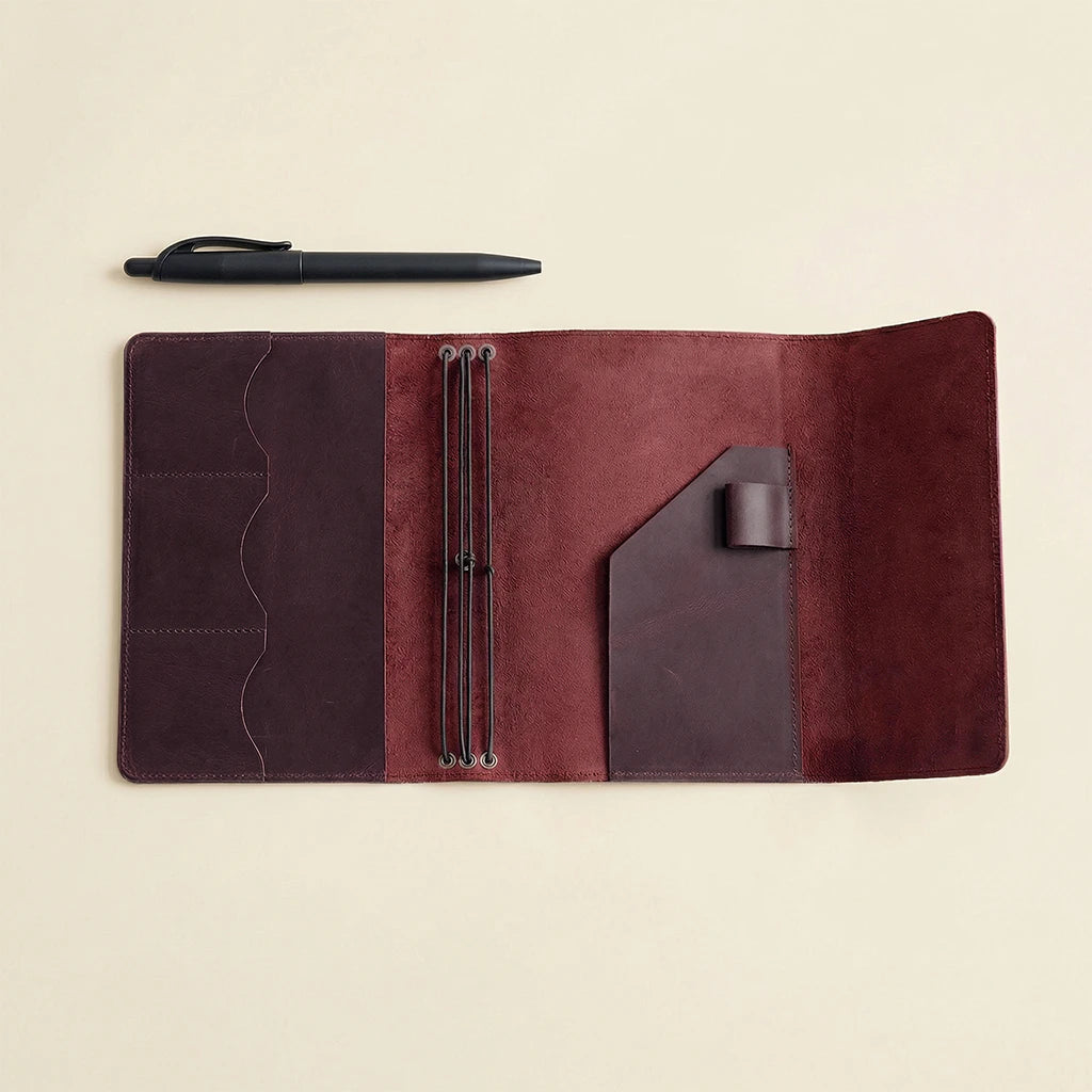 Brown leather journal with pen on a beige background