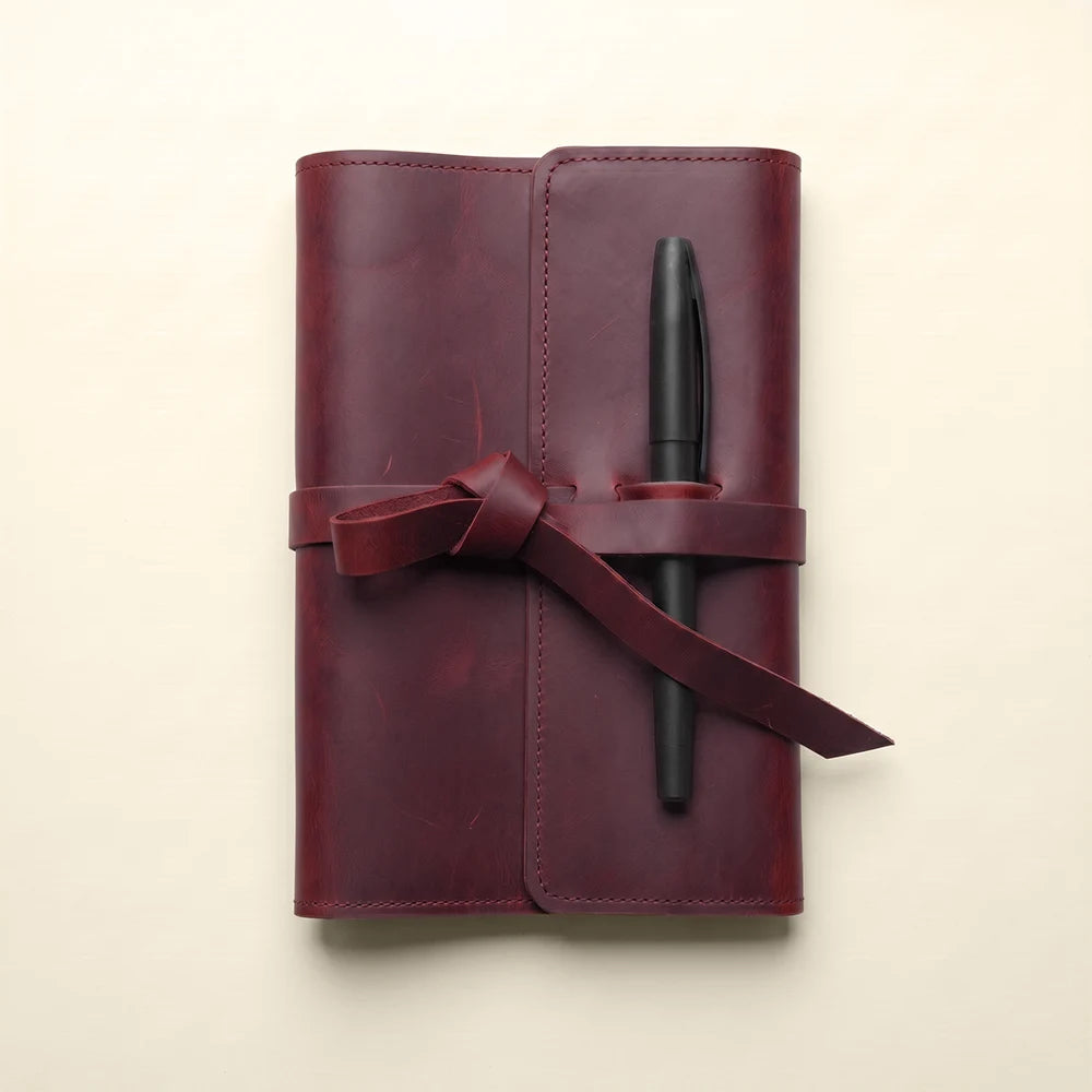 Handmade leather notebook cover offering card storage and convenient pen holder.