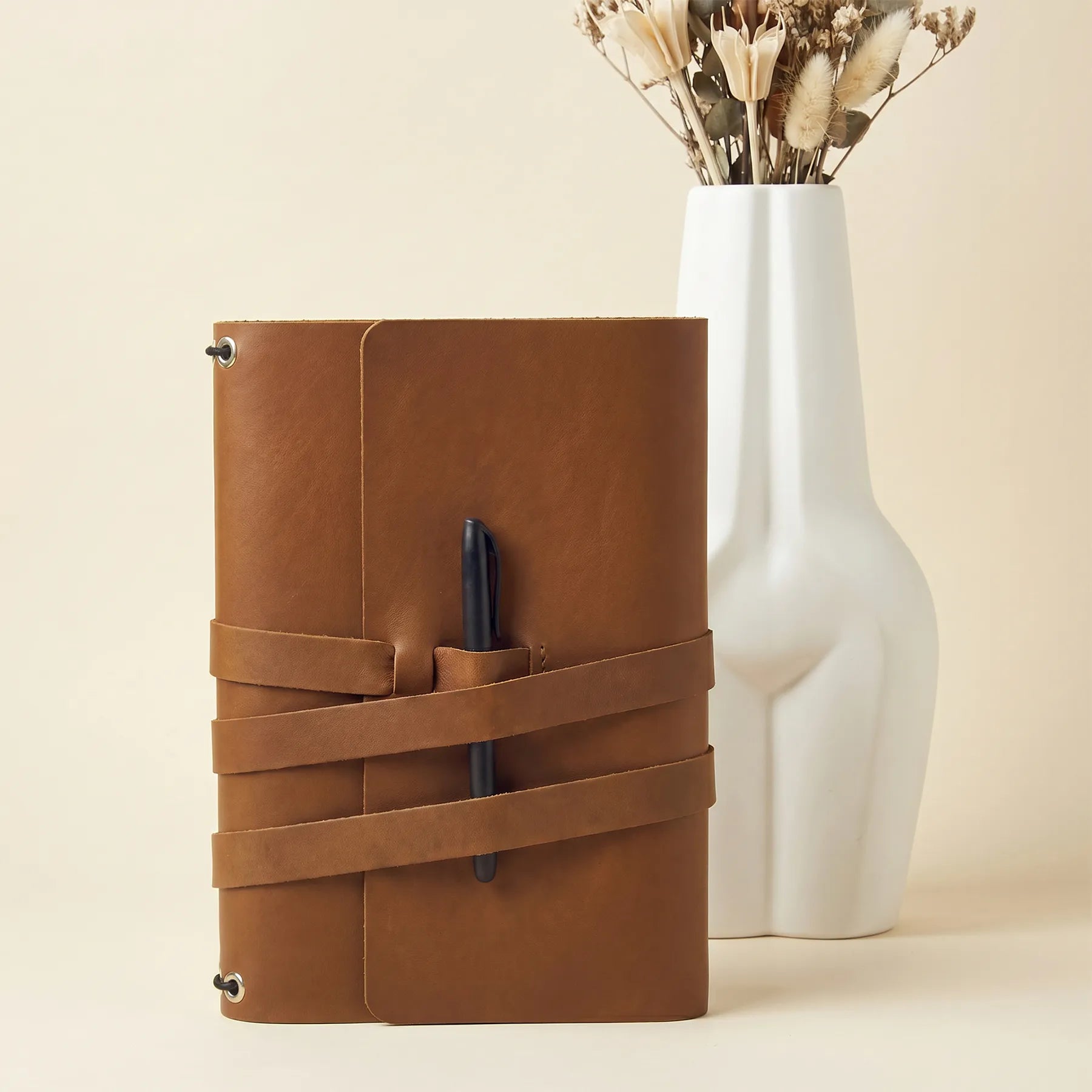 Refillable journal cover made from genuine leather with practical built-in pen holders.