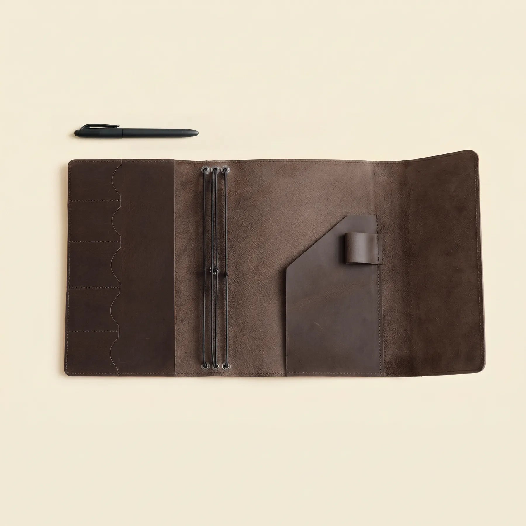 Leather cover for journals with three elastics and utility pockets.