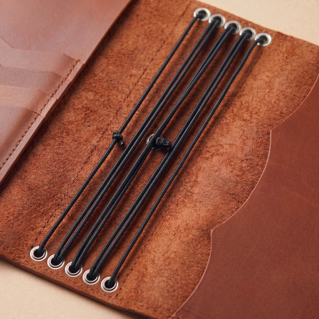Refillable notebook cover crafted from leather with secure pen loop