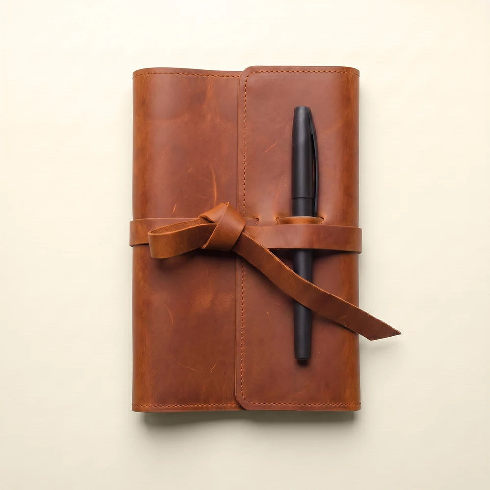 Handmade leather notebook organizer with spacious pockets and attached pen loop.