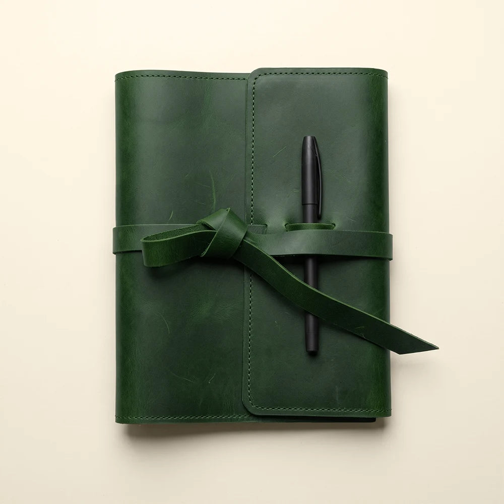 Genuine leather notebook cover designed with interior storage and pen holder.