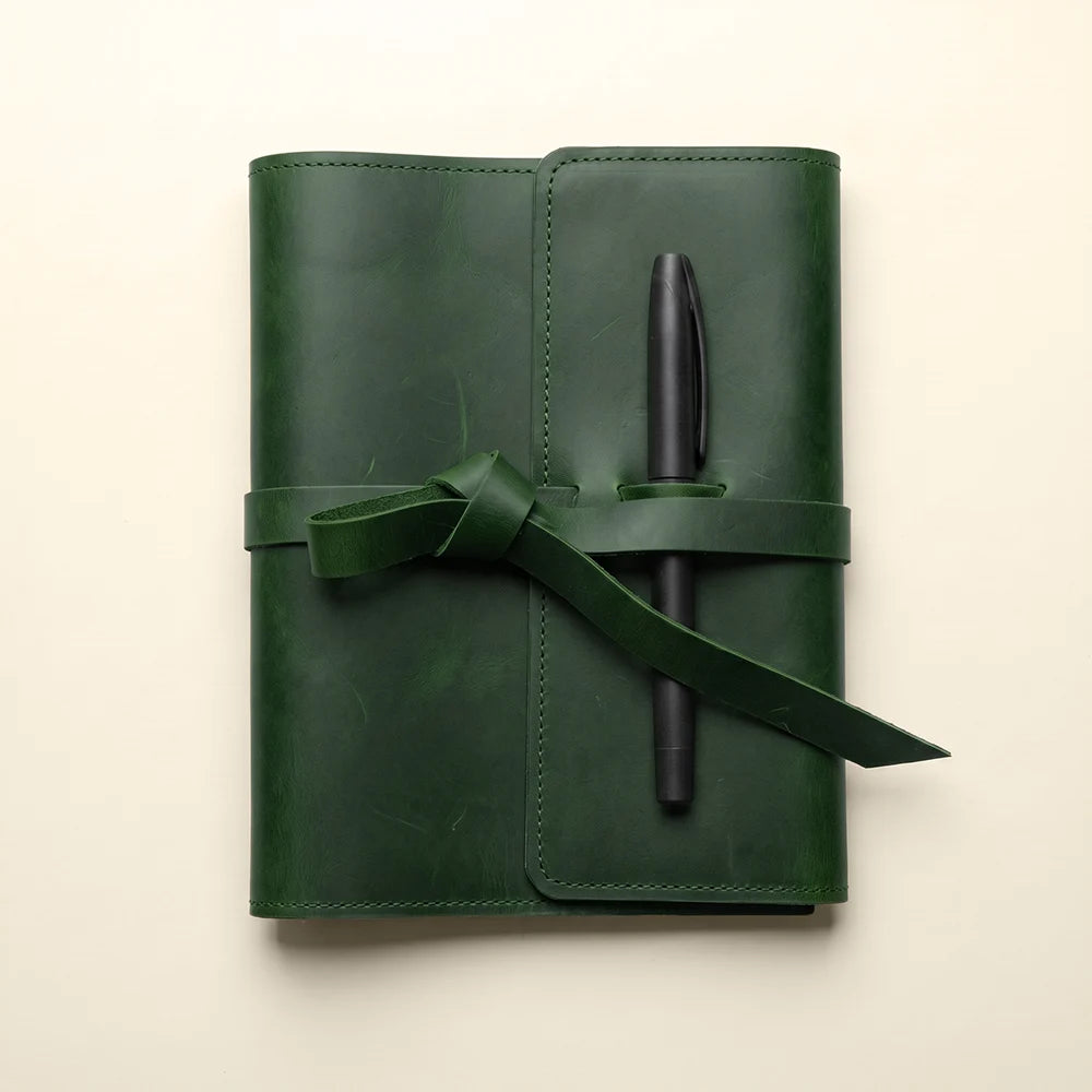 Leather writing cover with functional interior pockets and secure pen holder.