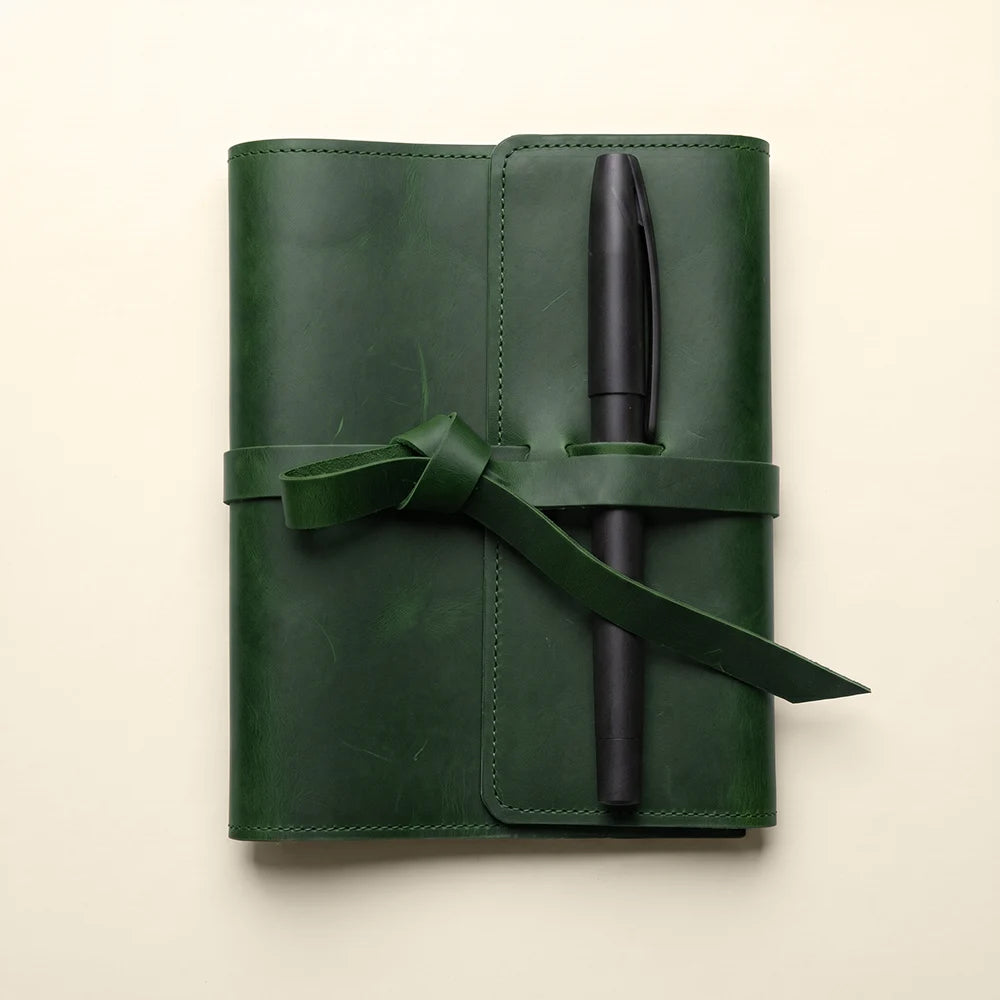 Leather travel journal cover with card slots, pen holder, and minimalist design.