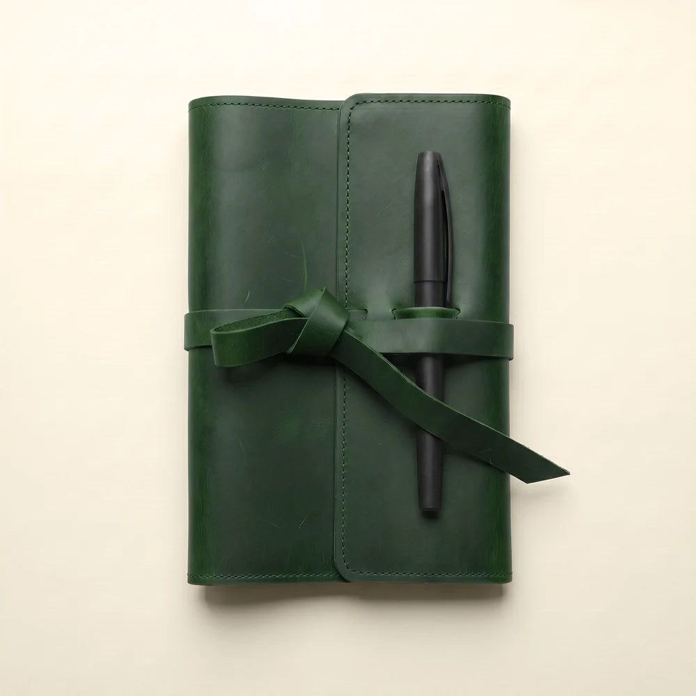 Leather notebook case with interior card slots and integrated pen loop.