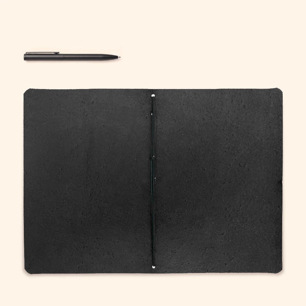 Open leather notebook sleeve displaying clean edges and a single elastic support.
