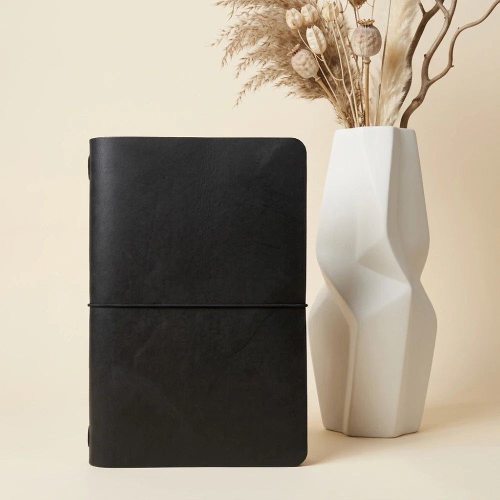 Minimalist leather notebook holder with smooth natural leather and one elastic strap.