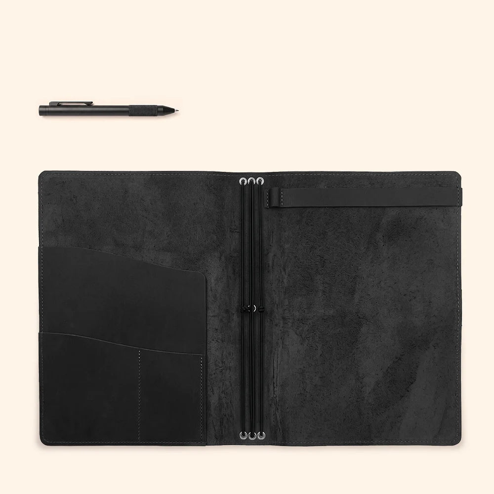 Handcrafted leather journal carrier with organized storage for multiple paper inserts.