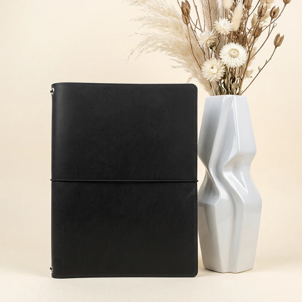 Refillable leather journal organizer with interior pockets, elastic loops, and sketchbook attachment.