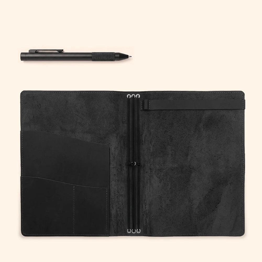 Leather notebook cover interior arranged with practical pockets and a secure sketchbook strap.