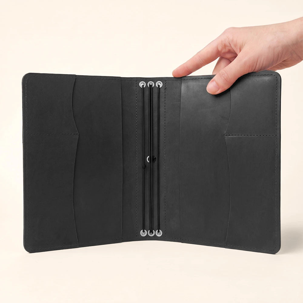 Handmade leather notebook cover with organized interior pockets and secure pen holder design.