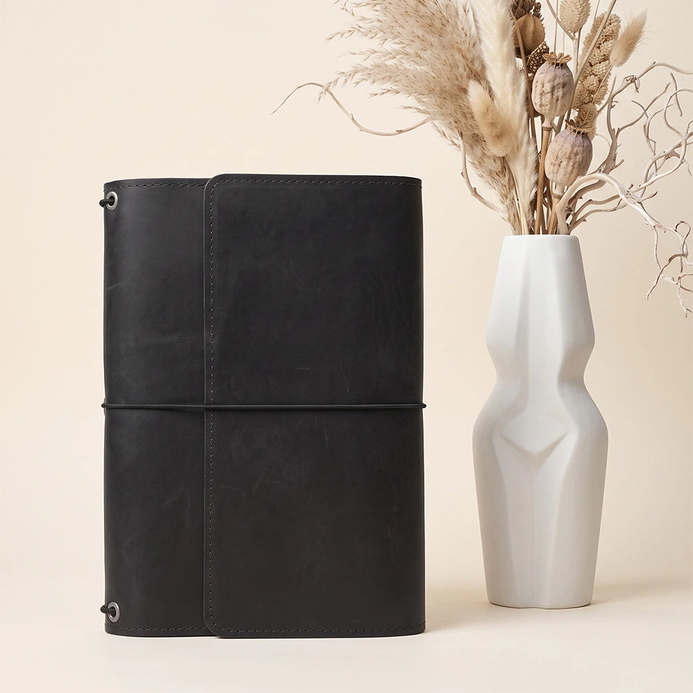 Natural leather notebook case with refined interior organization and integrated writing instrument loop.