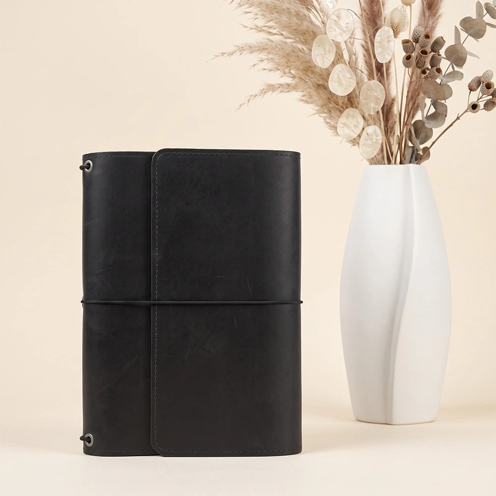 Natural leather notebook organizer designed with practical inner compartments and durable pen loop.