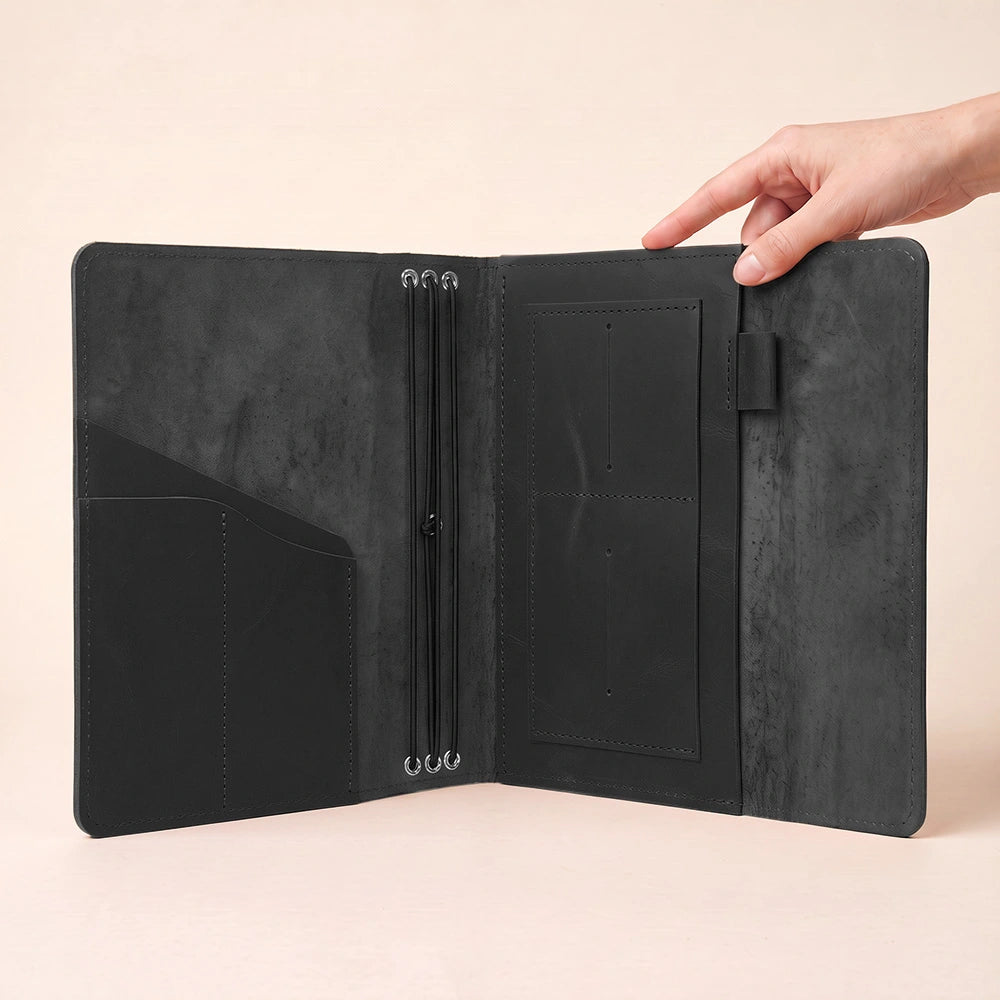 Leather notebook cover with refined craftsmanship, interior storage, and dedicated pen attachment.