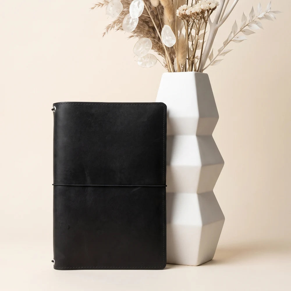 Handmade leather organizer designed for combining multiple notebook refills securely.