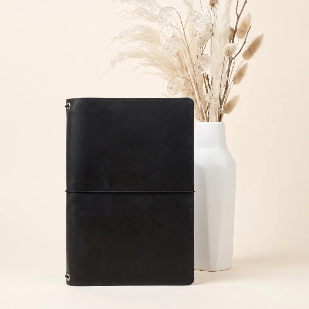 Natural leather holder with three elastic cords for a modular journaling setup.