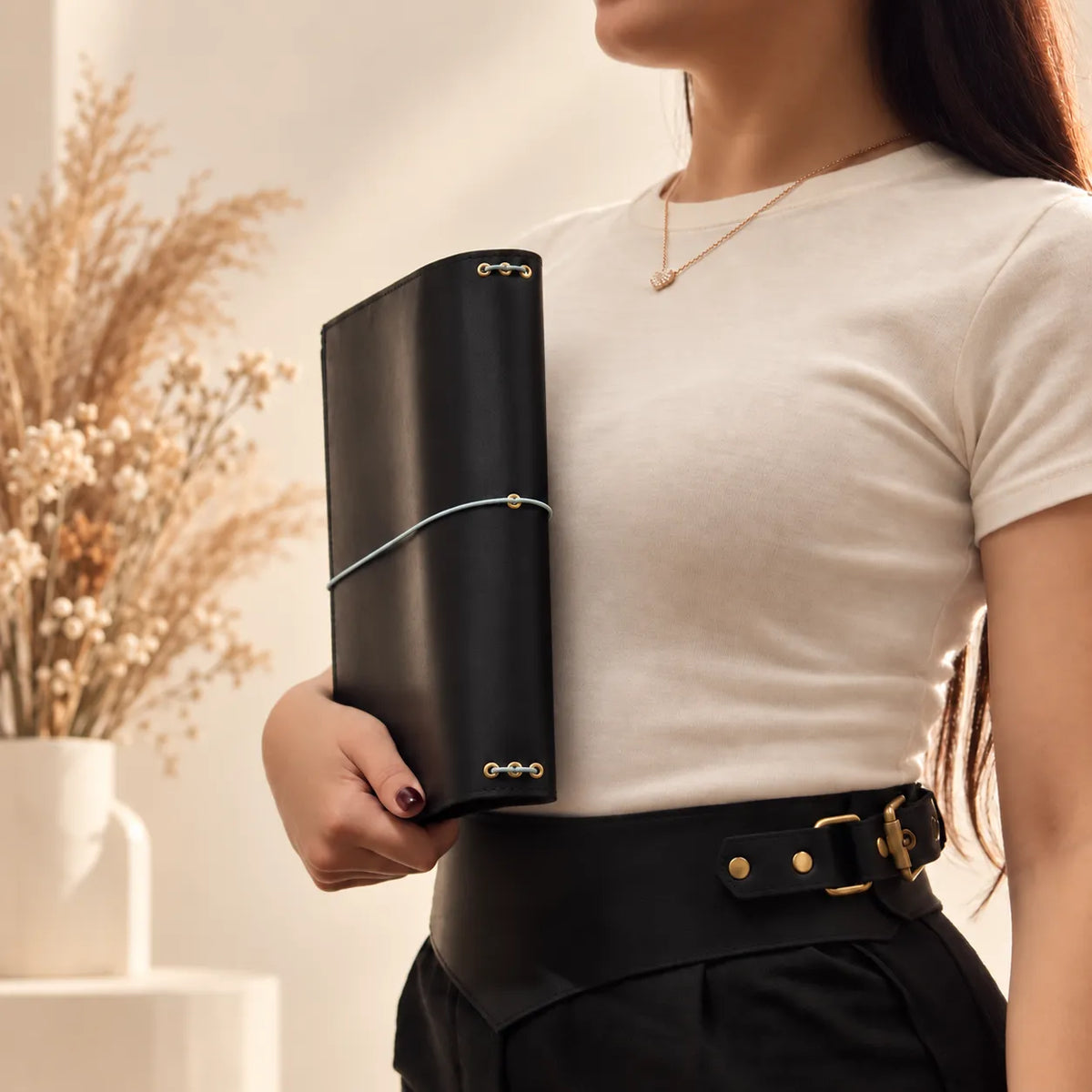 Woman presenting a genuine leather notebook cover while highlighting its soft natural leather texture.