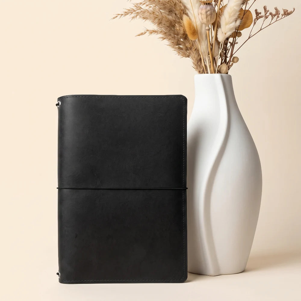 Refillable leather cover designed with three interior bands for interchangeable notebooks.
