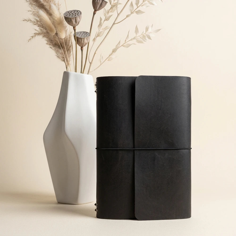 Natural leather notebook holder designed for six inserts using flexible elastic bands.